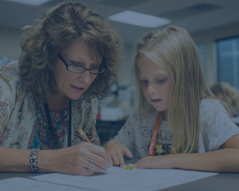 Teacher working with a 2nd grade student.
